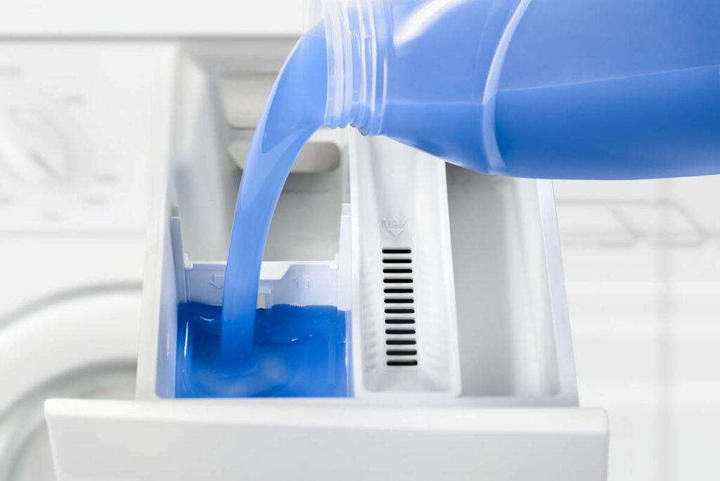 Close up of laundry detergent being poured into a washing machine, representing the Persil detergent class action.