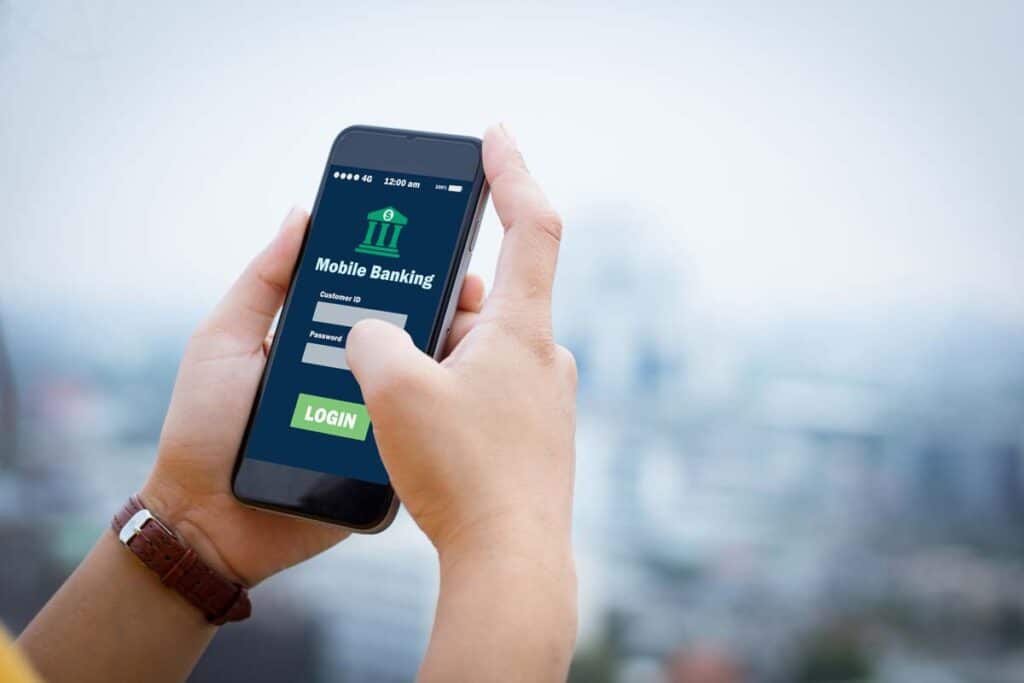 Close up of a womans hands logging into an online banking website on her smartphone, representing the Dollar Bank data breach class action.