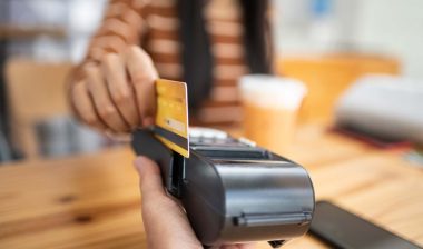Close up of a debit card being swiped on a point-of-sale machine, representing the Pioneer Bank overdraft fees class action.