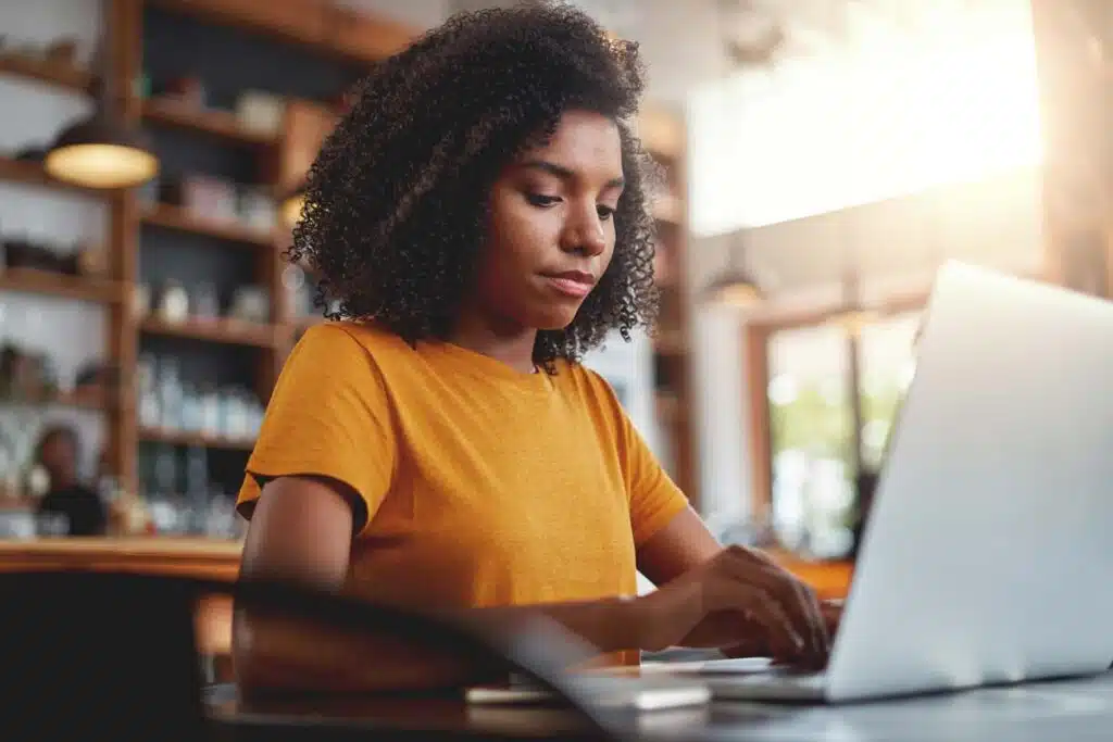 A young woman typing on a laptop, representing the Publishers Clearing House class action lawsuit.
