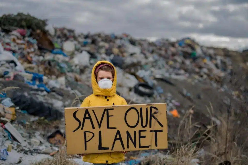 A small child holding a sign that reads 'Save Our Planet,' representing the kids climate lawsuit.