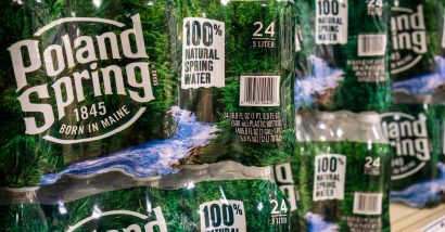 Packaged Poland Springs water bottles on a grocery store shelf, representing the Poland Spring false advertising lawsuit.