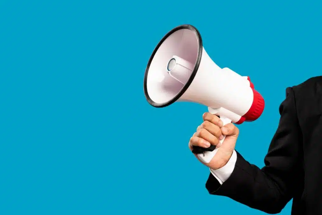 Close up of a businessman holding a megaphone, representing top recalls for the week of Dec. 4.