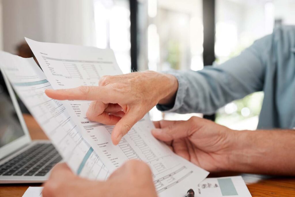 Close up of a woman's hands pointing to a charge on a bill, representing the Great Lakes Water Authority IWC class action settlement.