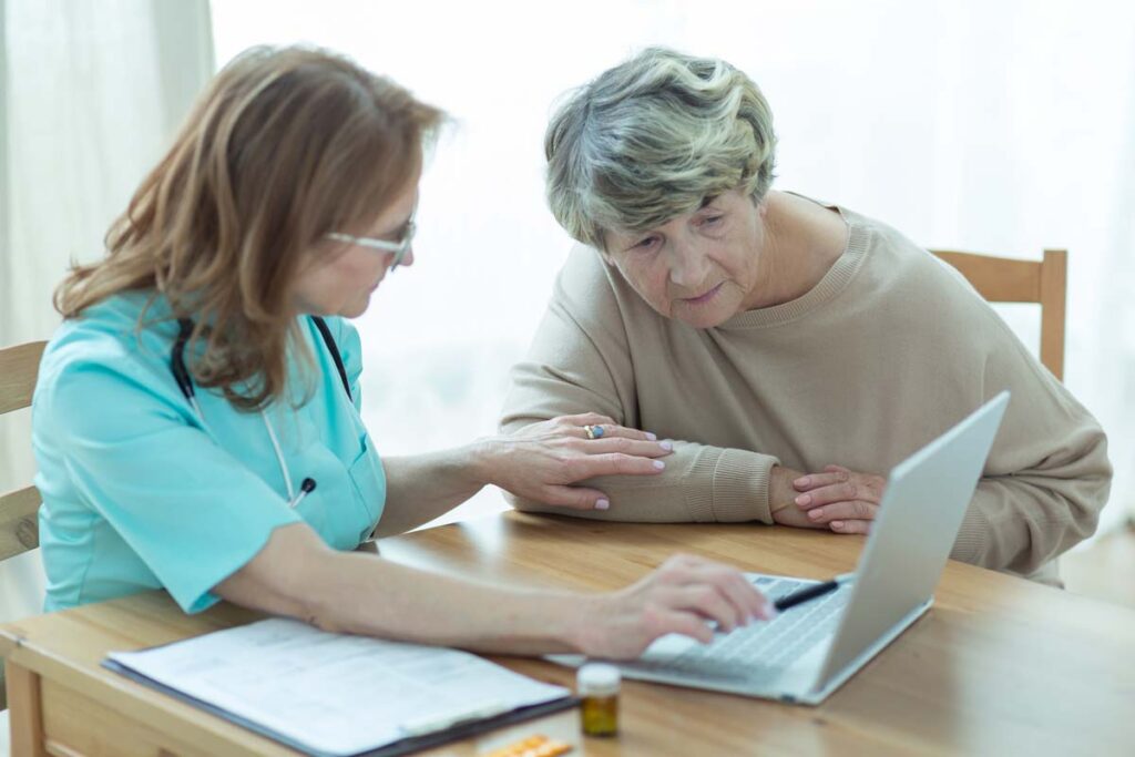 At home doctor looking at a laptop with her patient, representing the DPP and Home Care Providers of Texas data breach class action lawsuit settlement.