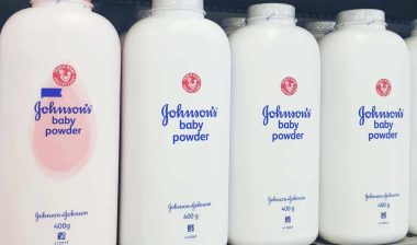 Johnson & Johnson baby powders on a supermarket shelf, representing the Johnson & Johnson talc baby powder settlement.