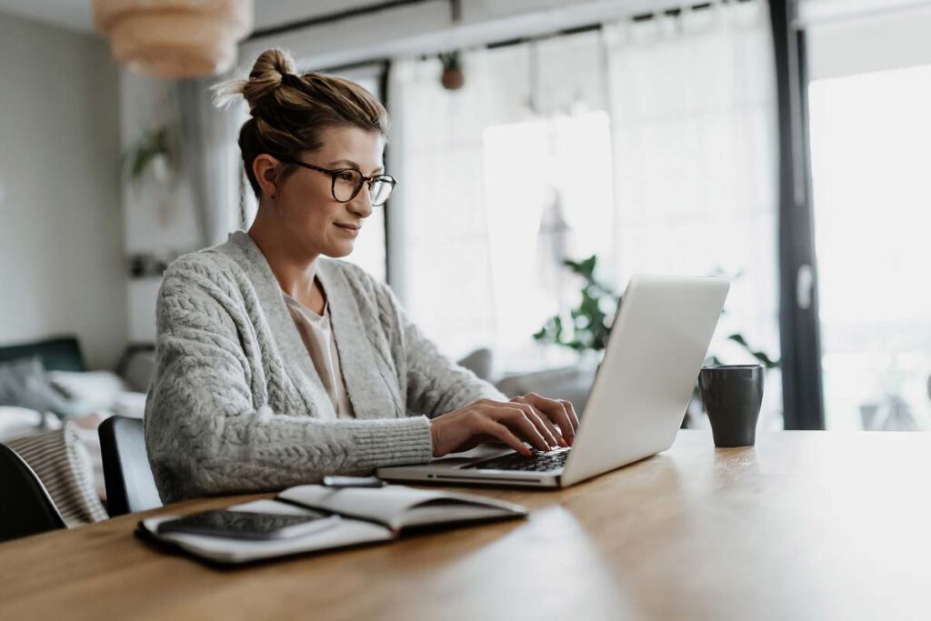 A woman typing on her laptop while working from home, representing the Amazon class action.
