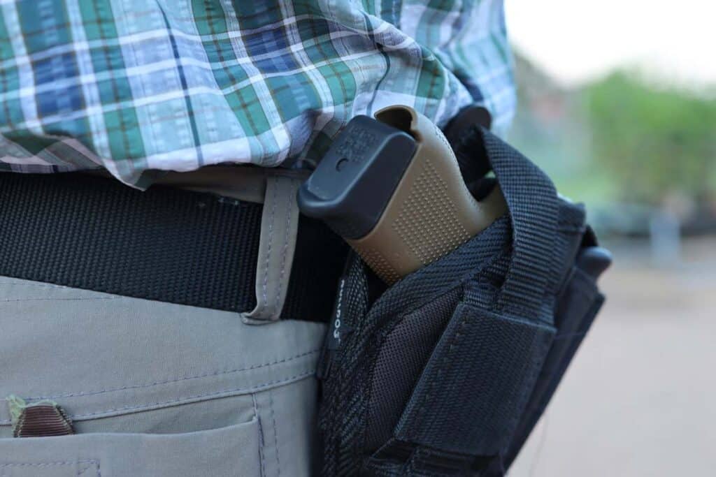 Close up of a holstered gun on a belt loop, representing the Washington, D.C., MPD gun control settlement.