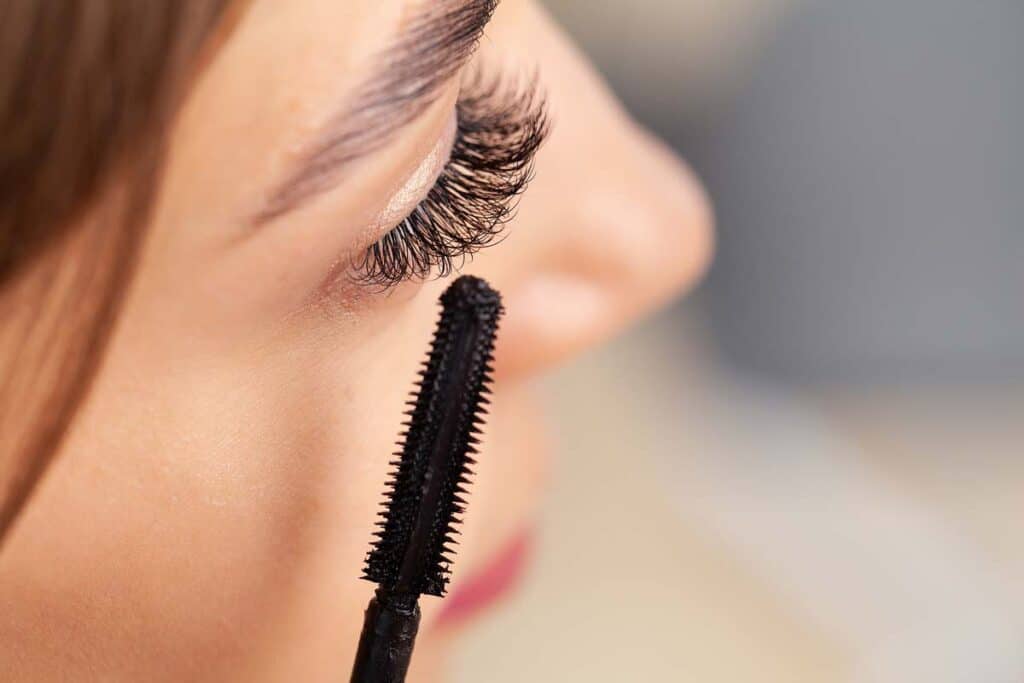 Close up of a woman putting on mascara, representing the Grande Cosmetics class action lawsuit settlement.