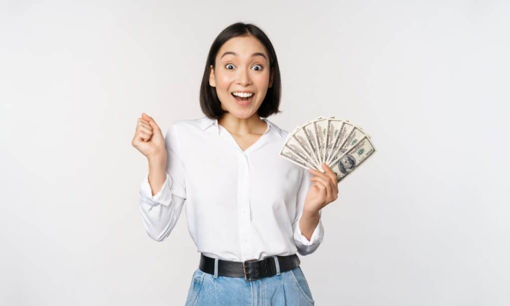 Happy woman with cash in hand, representing recent settlement payments to consumers.