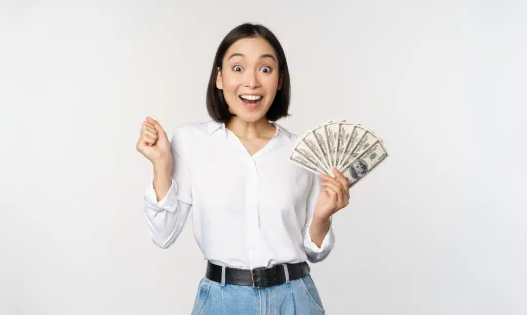 Happy woman with cash in hand, representing recent settlement payments to consumers.
