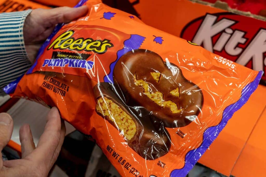 Close up of a mans hands holding a package of Reese's Pumpkins, representing the Reese's peanut butter class action lawsuit.