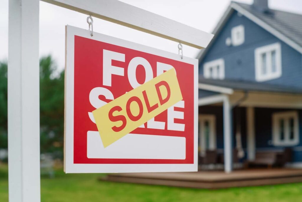 Close up of a SOLD sticker on a For Sale sign, representing the Re/Max and Anywhere settlement.