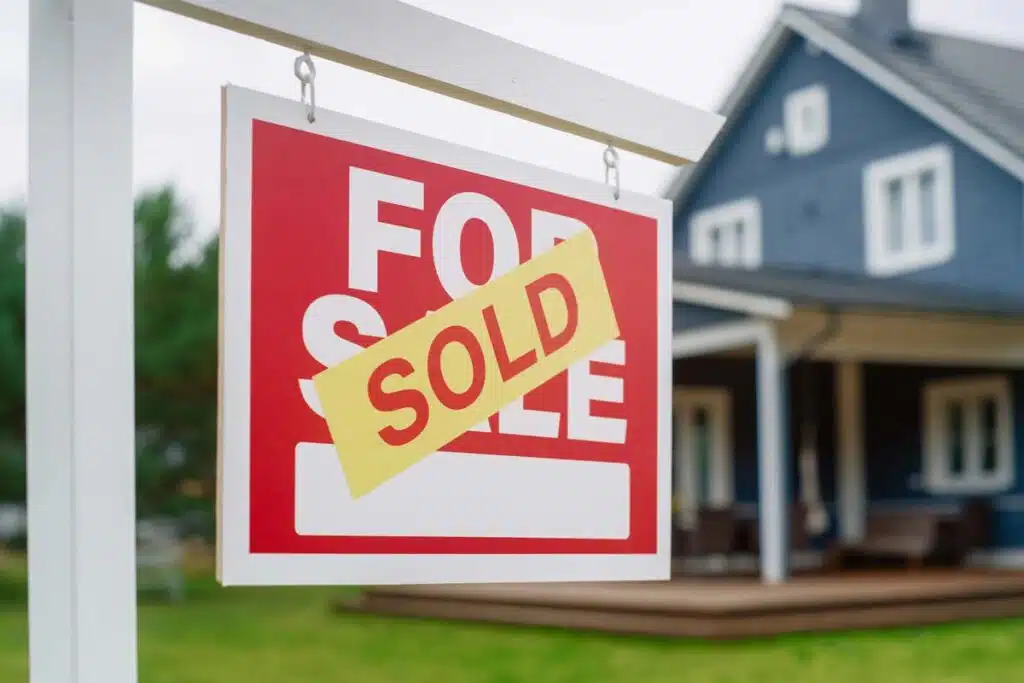 Close up of a SOLD sticker on a For Sale sign, representing the Re/Max and Anywhere settlement.