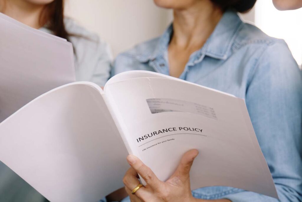 Close up of a woman holding an insurance policy booklet, representing the Benefytt insurance settlement.