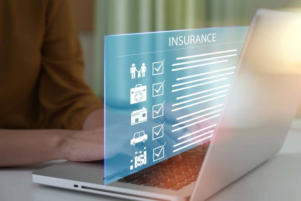 Close up of a woman typing on a laptop with a insurance checklist concept overlay, representing recent insurance class actions and settlements.