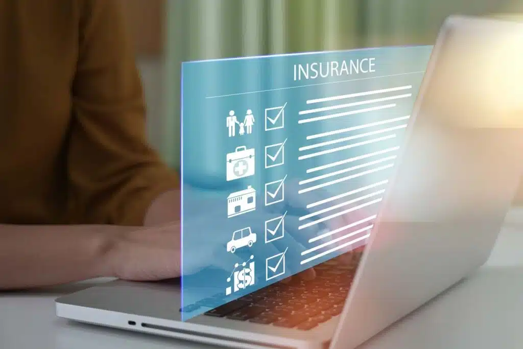 Close up of a woman typing on a laptop with a insurance checklist concept overlay, representing recent insurance class actions and settlements.