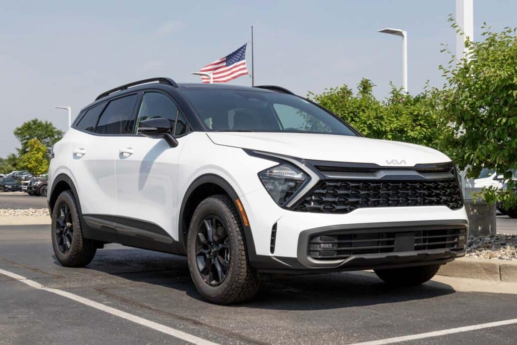 A white Kia Sportage in a dealership lot, representing the Kia recall.