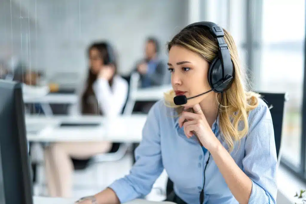 A female telemarketer with a headset making a call, representing the Bath Fitter class action.