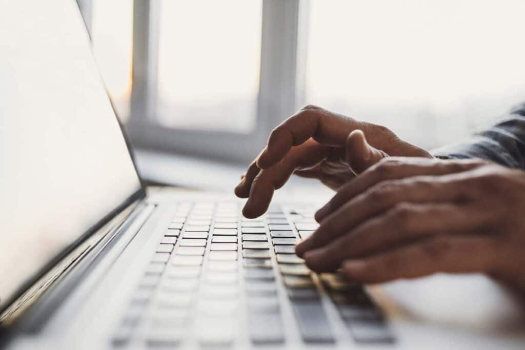 Close up of hands typing on a laptop keyboard, representing the Lending Tree data breach class action lawsuit settlement.