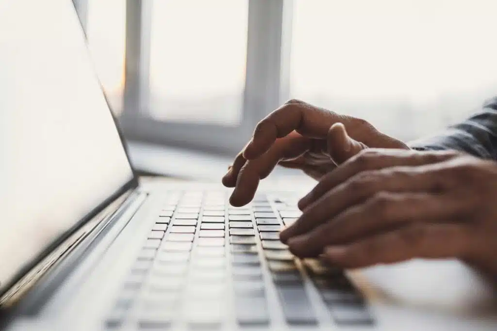 Close up of hands typing on a laptop keyboard, representing the Lending Tree data breach class action lawsuit settlement.