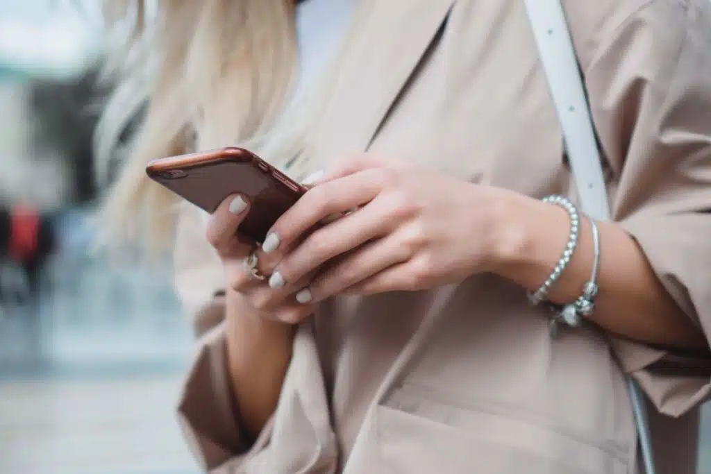 Close up of a womans hands using a smartphone, representing the Legoland New York class action.