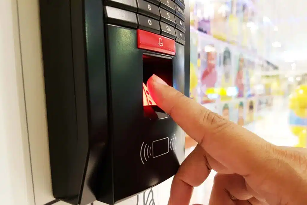 Close up of an employee using a fingerprint time clock machine, representing the C Studio Manufacturing settlement.