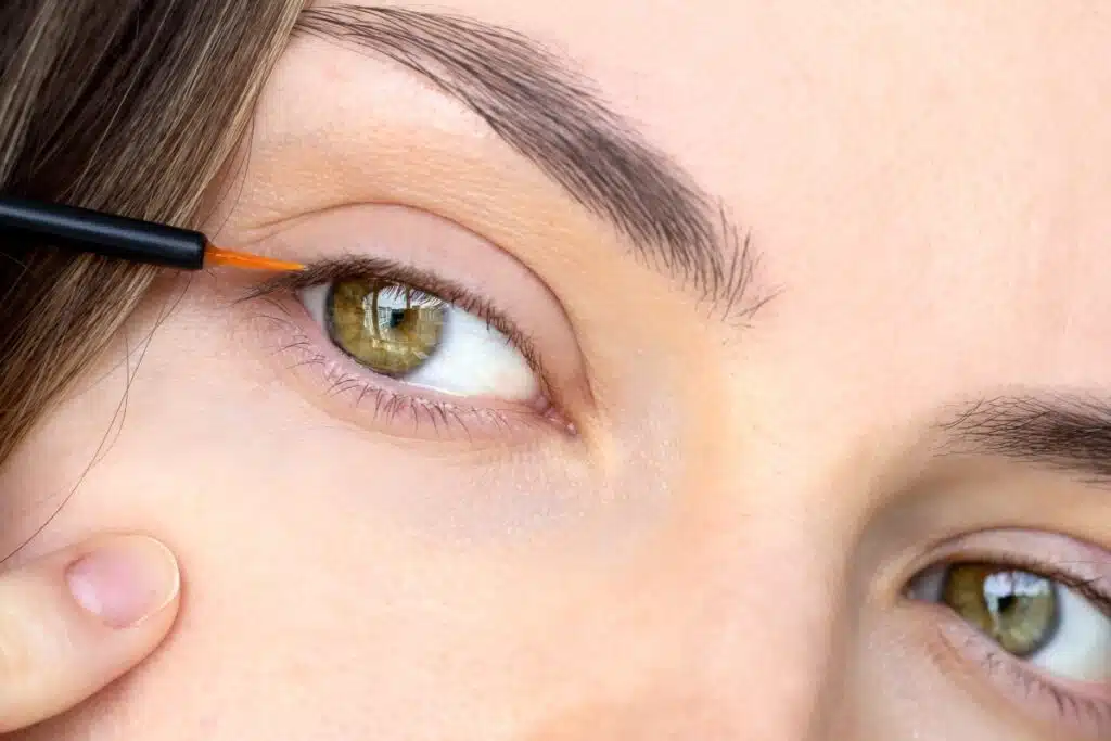 Closeup of a woman applying lash serum, representing the Babe Lash settlement.