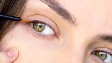 Closeup of a woman applying lash serum, representing the Babe Lash settlement.