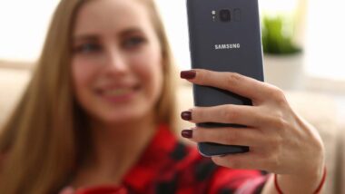 A woman taking a selfie on a Samsung phone, representing Samsung biometric data arbitration.