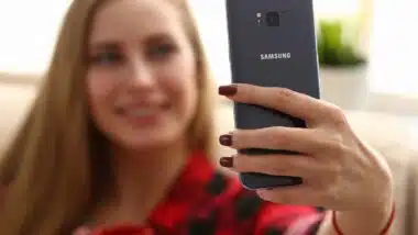 A woman taking a selfie on a Samsung phone, representing Samsung biometric data arbitration.