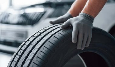 Close up of a mechanic with his hands on a new tire, representing the tire class action.