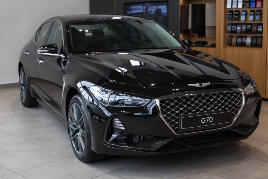 A black Genesis G70 in a Hyundai showroom, representing the Hyundai recall.