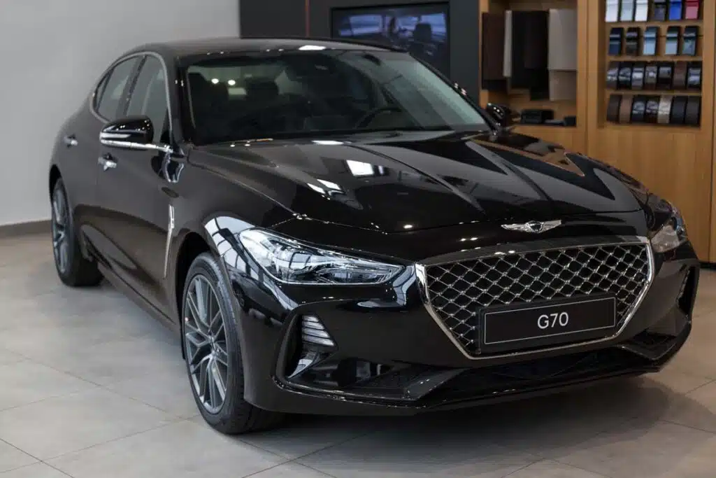 A black Genesis G70 in a Hyundai showroom, representing the Hyundai recall.