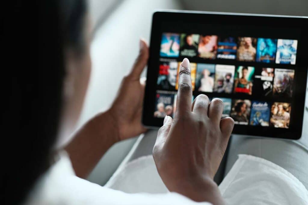 Woman searching for movies on her tablet, representing the AMC class action lawsuit settlement.