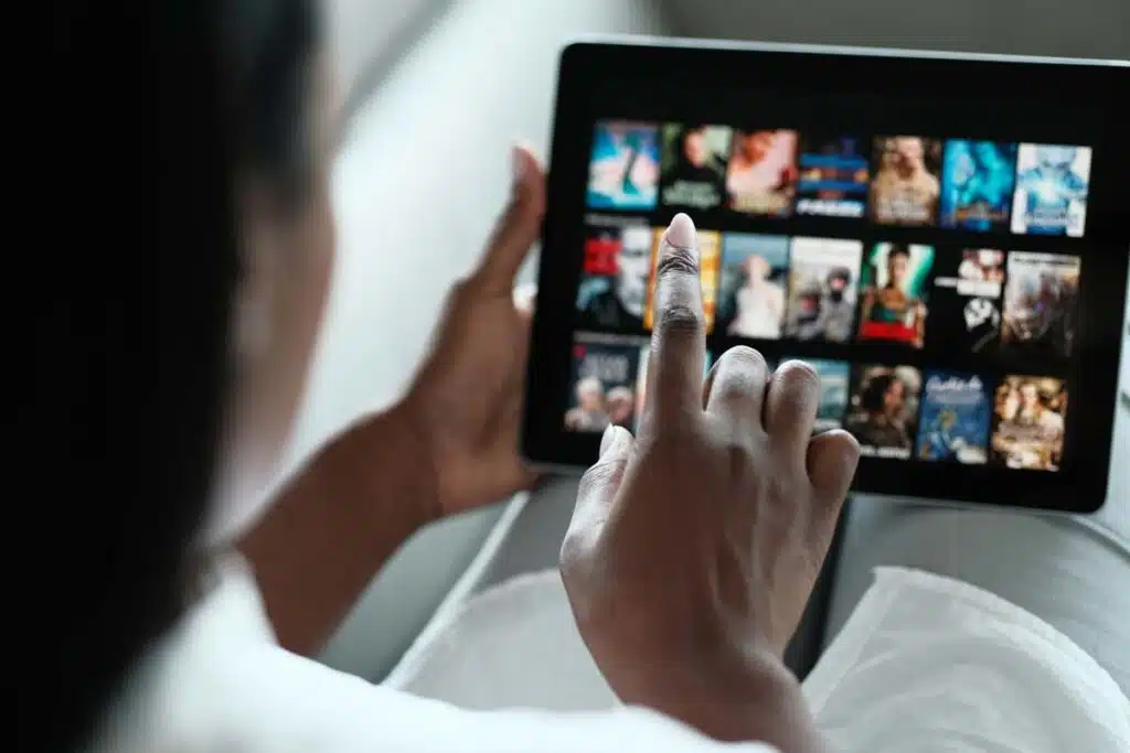 Woman searching for movies on her tablet, representing the AMC class action lawsuit settlement.