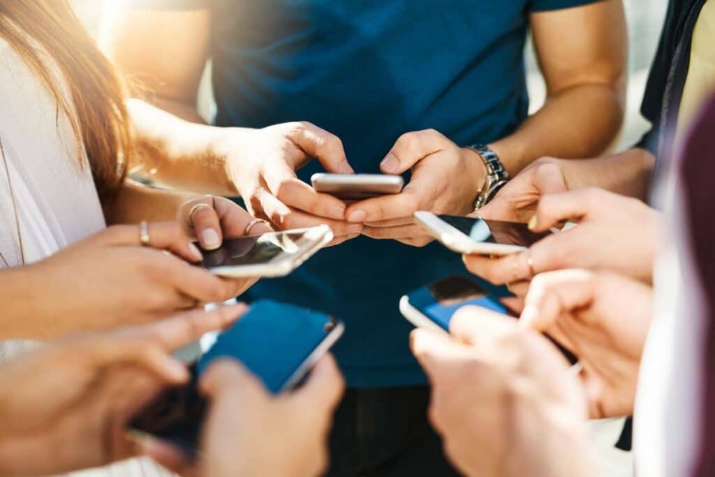 Close up of a group of individuals using their smartphone, representing recent data breach incidents.
