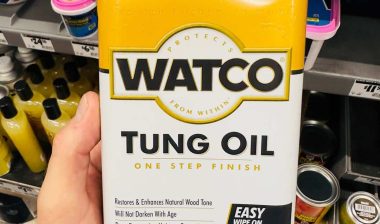 Close up of hand holding Watco Tung Oil product, representing the Rust-Oleum class action lawsuit.