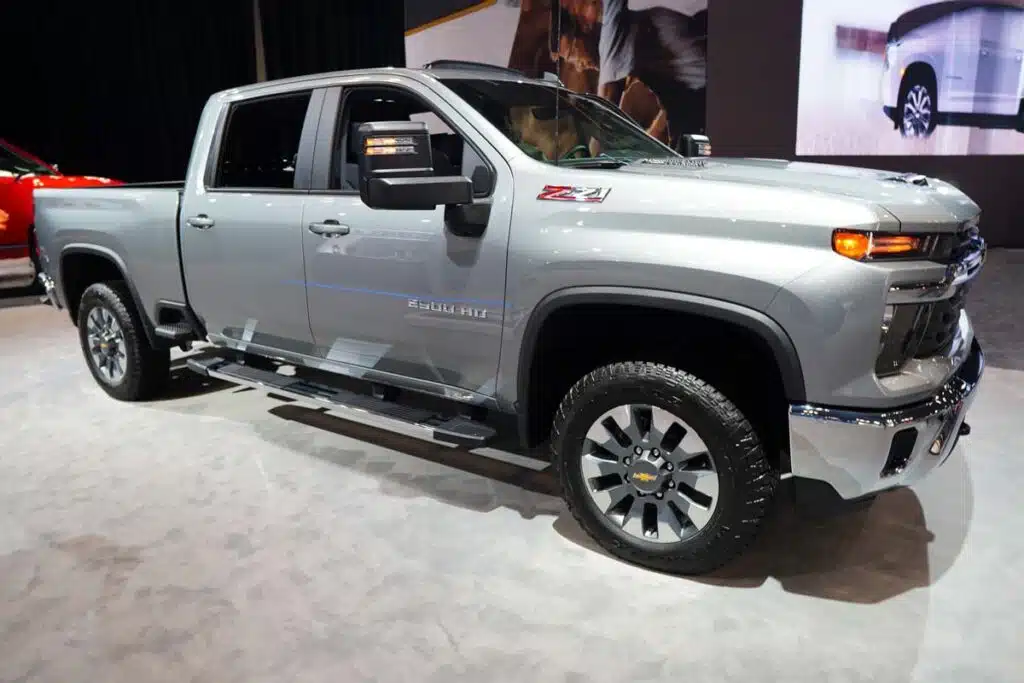 A 2024 silver Chevrolet Silverado 2500 at a car show, representing the GM truck recall over a potential tailgate unlatch issue.