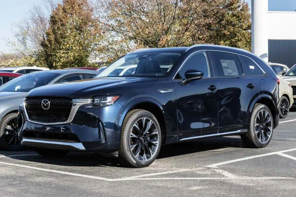 A blue Mazda CX-90 in a dealership lot, representing the Mazda steering defect recall.