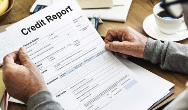 Close up of an elderly man reading his credit report, representing the Universal Credit Services class action settlement.