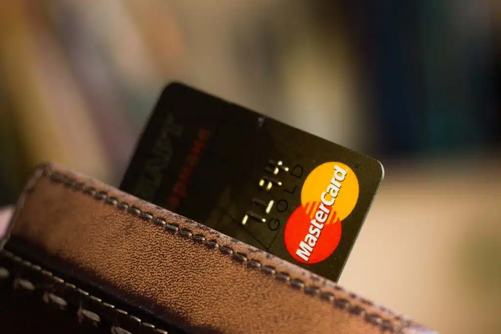 Mastercard credit card peeking out of a wallet, representing the Amazon and Mastercard settlement.