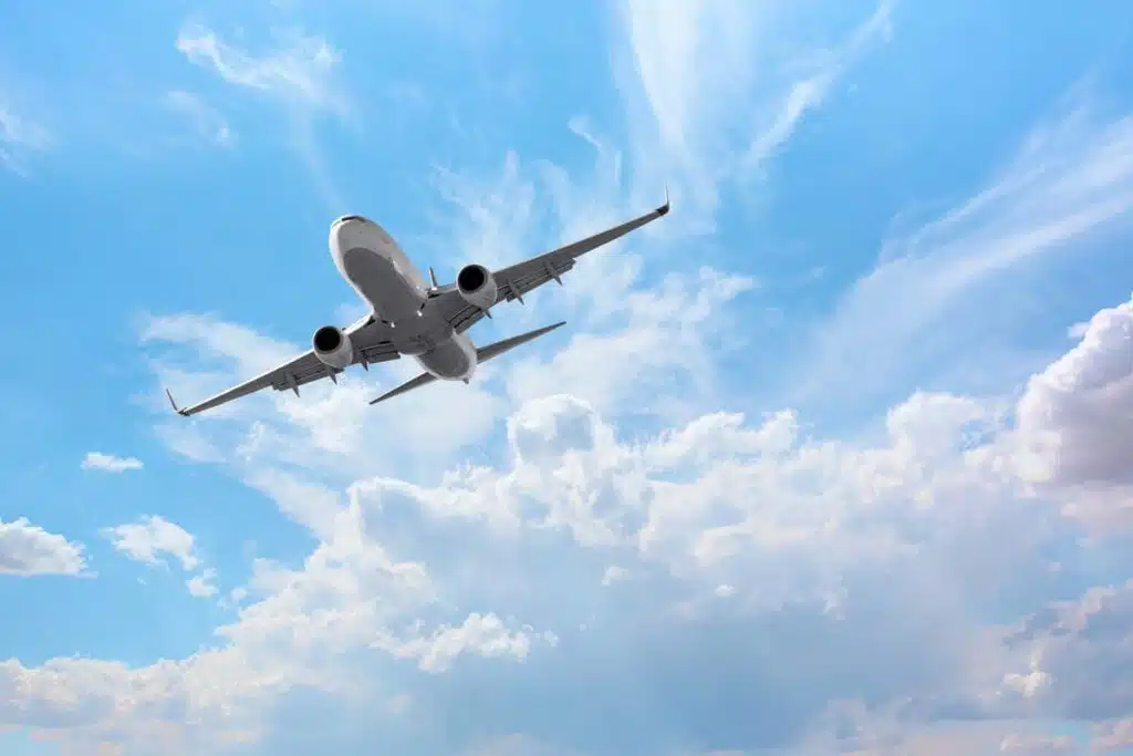 Bottom view of a plane in the sky, representing the airlines lawsuits.