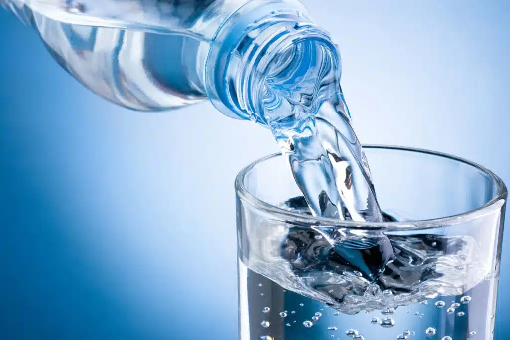 Close up of water from a bottle being poured into a glass, representing the water lawsuits.