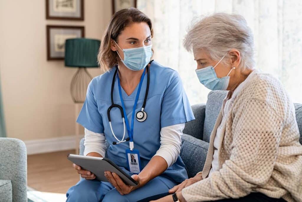 Home health nurse using a tablet with a patient, representing the Personal Touch data breach class action lawsuit settlement.