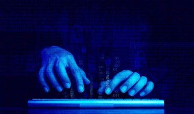 Close up of a hacker typing on a keyboard with a binary code overlay, representing the Southland Holdings data breach settlement.