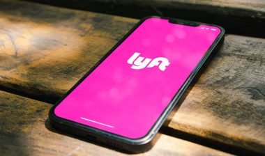 Close up of Lyft logo displayed on a smartphone screen, representing the New York Lyft drivers attorney general settlement.