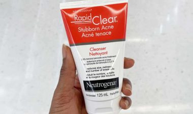 Close up of a hand holding a Neutrogena benzoyl peroxide product, representing the Neutrogena class action.