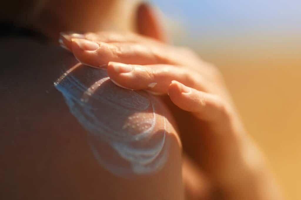 Close up of woman putting sunscreen on her shoulder, representing the MISSHA and A'pieu sunscreen case action.