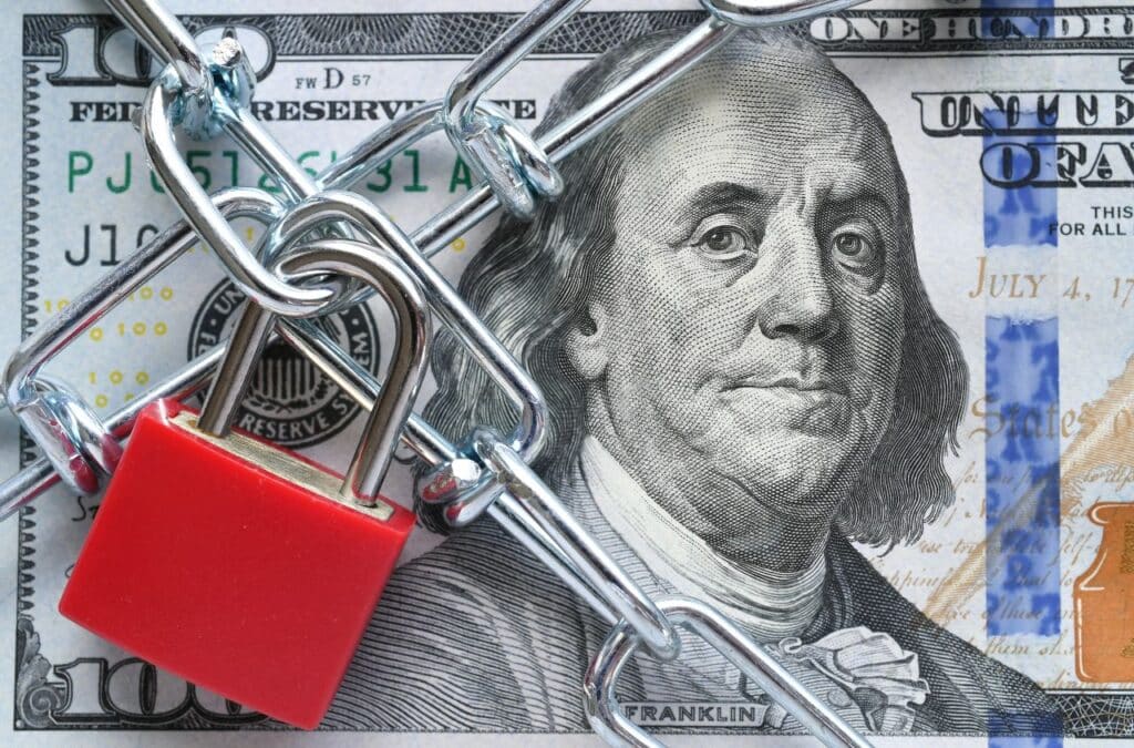 Locked down $100 dollar bill, representative of freezing interest on accounts.